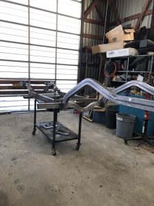 Barrys Custom Fab chassis in front of shop doors